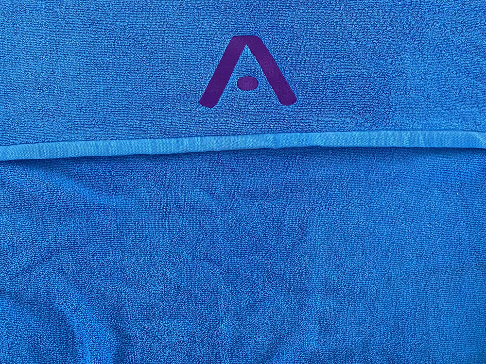 Blue terry prototype towel with the purple A logo