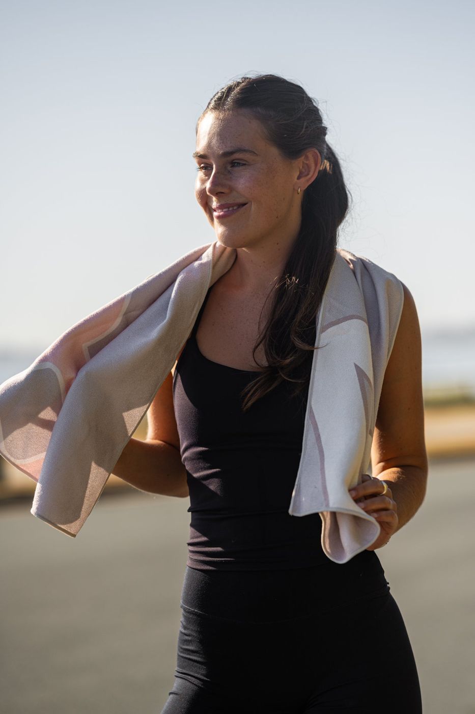 Hoodless Gym Towel in Lume over the shoulders at the beach