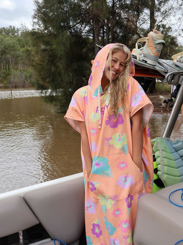Smiling woman in a floral hooded towel poncho on a boat